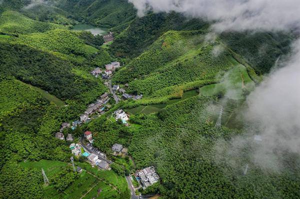Mogan Mountain emerges through clouds, mist after rain